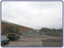 Factory yard beyond road and bridge